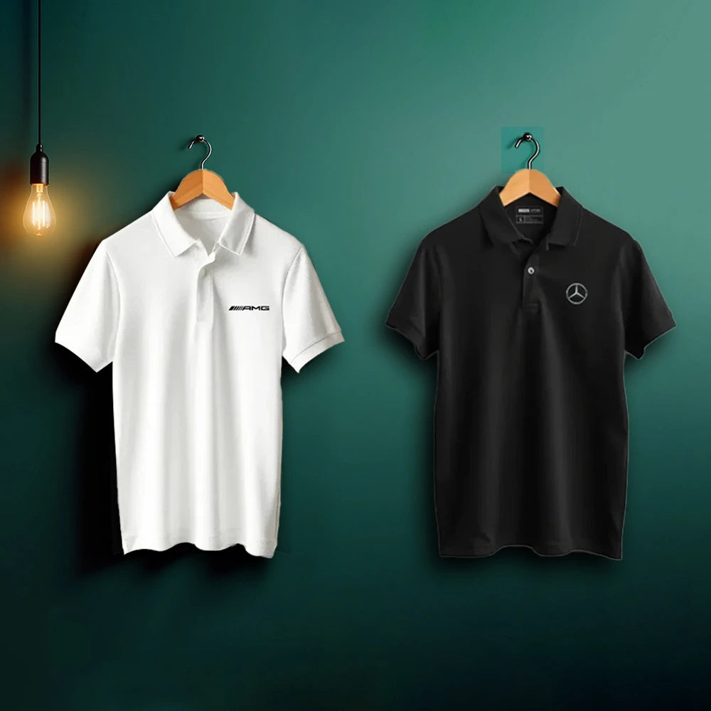 White and black polo shirts with logos on hangers against a green background
