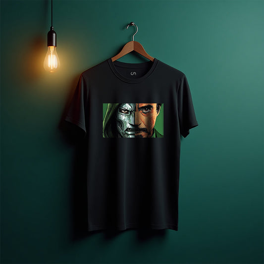 A black short-sleeve graphic t-shirt hanging on a wooden hanger against a dark teal-green wall, illuminated by a warm hanging light bulb. The shirt features a rectangular graphic print of a split-face portrait showing metallic silver and human skin tones.