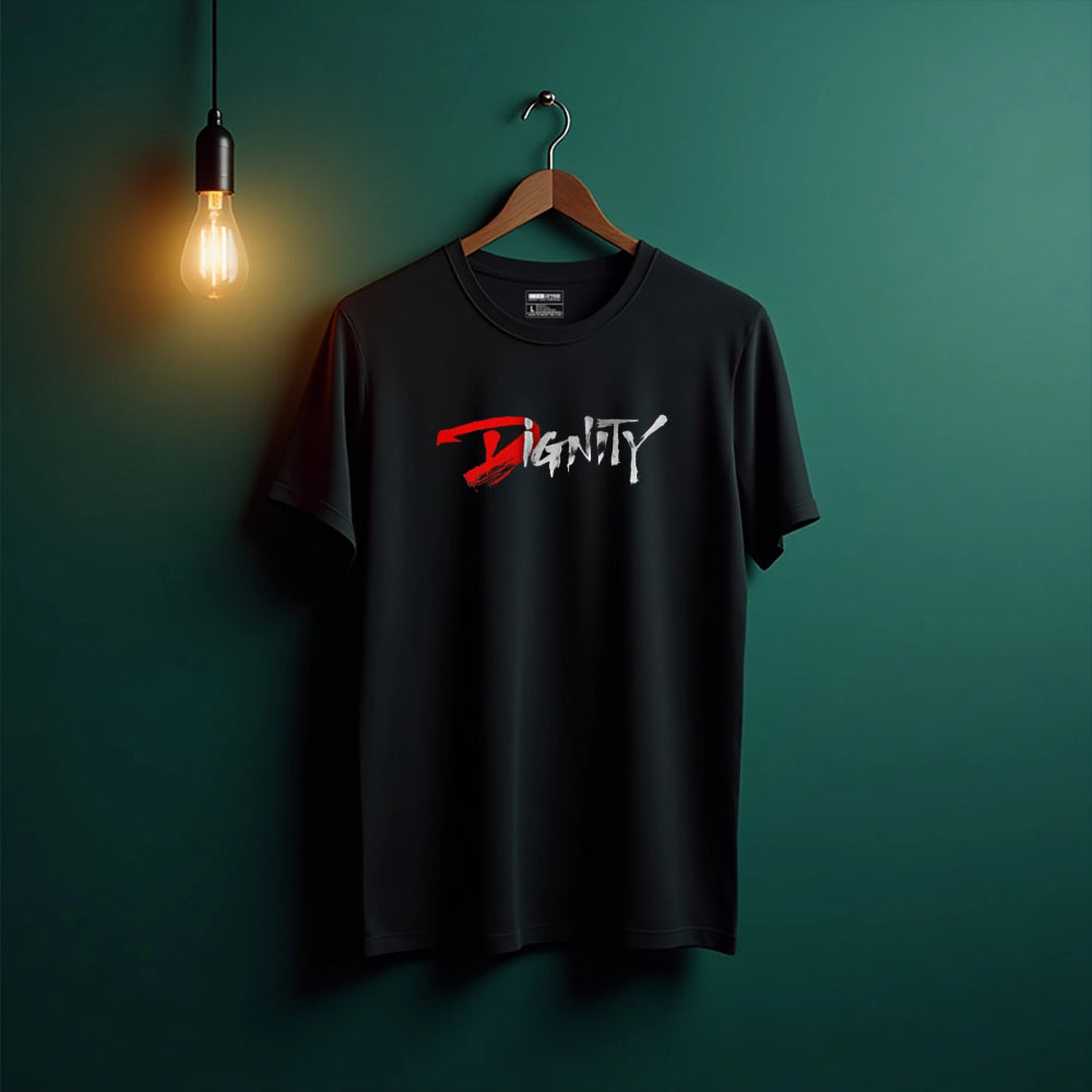 Black t-shirt with 'Dignity' design on a hanger against a green wall with a light bulb.