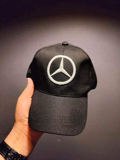 Black cap with Mercedes-Benz logo held against a dark background