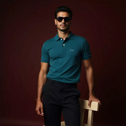 Man wearing a teal polo shirt and sunglasses against a dark background